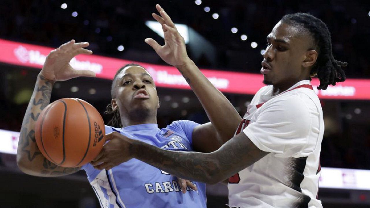 North Carolina forward Armando Bacot, left, and North Carolina State forward Greg Gantt, right, try to control a rebound during the first half of an NCAA college basketball game, Sunday, Feb. 19, 2023, in Raleigh, N.C. (AP Photo/Chris Seward)