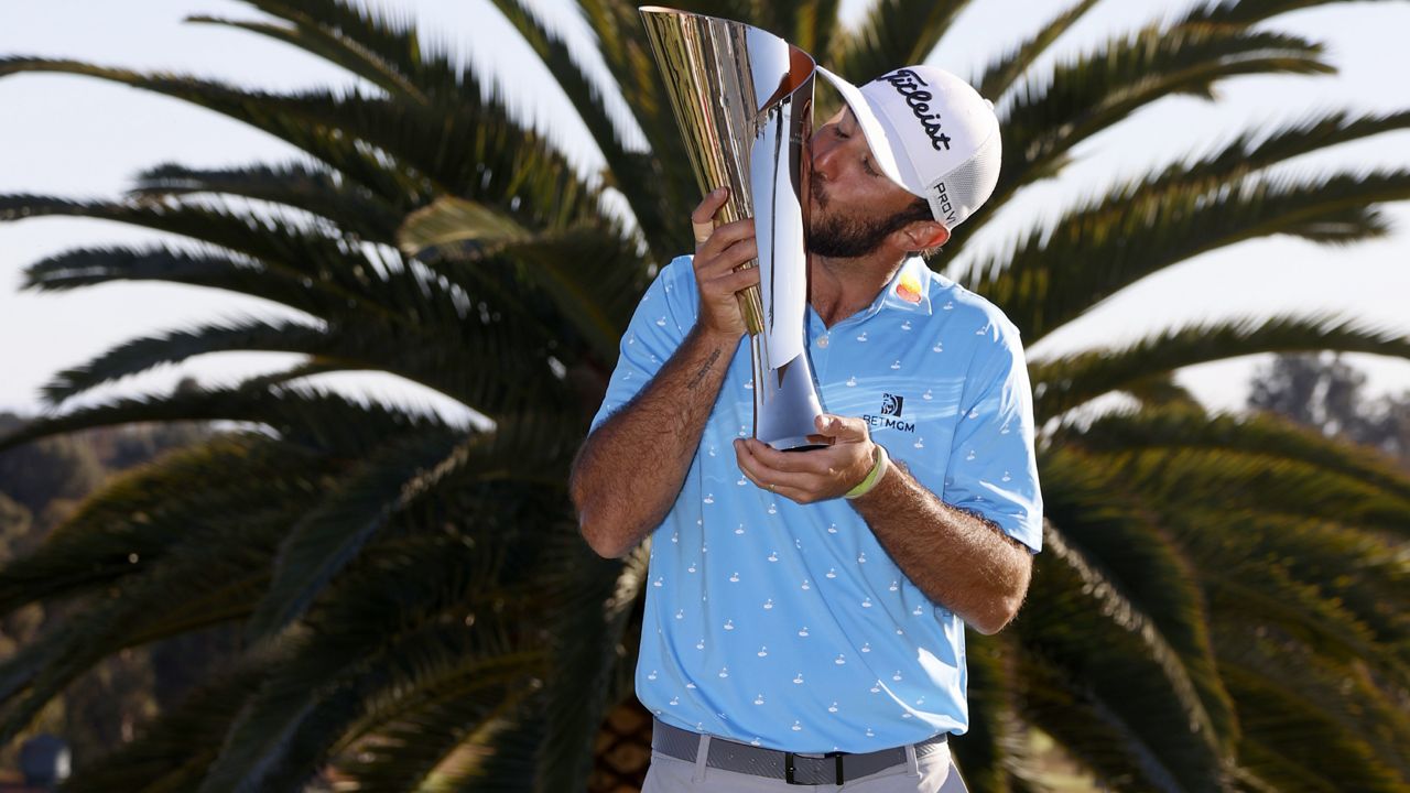 Max Homa kisses his trophy on the practice green after winning the Genesis Invitational golf tournament at Riviera Country Club, Sunday, Feb. 21, 2021, in the Pacific Palisades area of Los Angeles. (AP Photo/Ryan Kang)