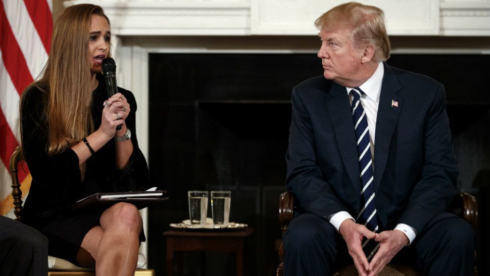 President Donald Trump, looks to Julia Cordover, the student body president at Marjory Stoneman Douglas High School in Parkland, Fla., as she speaks during the listening session with high school students, teachers, and others in the State Dining Room of the White House in Washington, Wednesday, Feb. 21, 2018. (AP Photo/Carolyn Kaster)