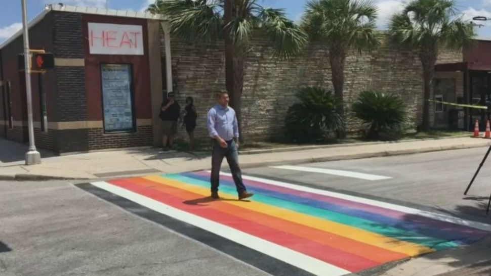 A pedestrian walks between the Pride Crosswalk at the intersection of N. Main and Evergreen (Spectrum News/File)