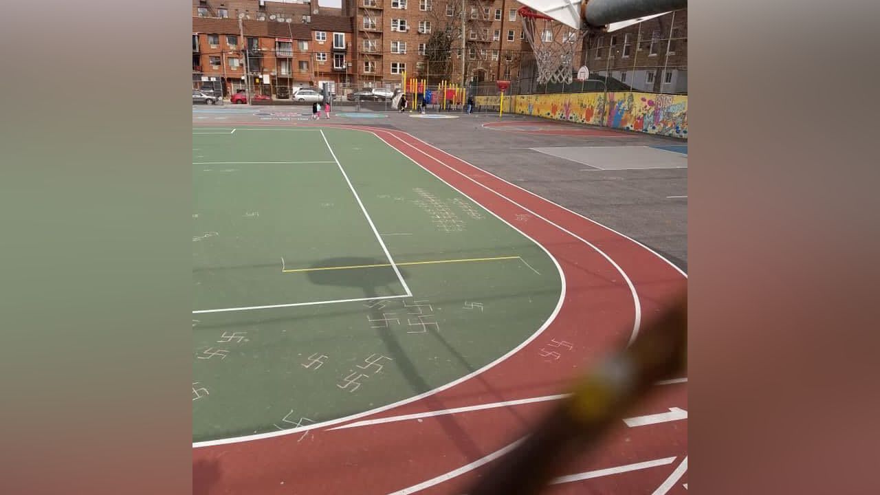 Swastikas on a green grass playground and red track.