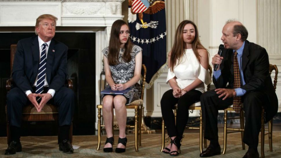 From left, President Donald Trump, Marjory Stoneman Douglas High School student students Carson Abt, and Ariana Klein, listen as Carson’s father Frederick Abt, speaks during a listening session with high school students, teachers, and others in the State Dining Room of the White House in Washington, Wednesday, Feb. 21, 2018. In the aftermath of yet another mass school shooting, Trump says that if one of the victims, a football coach, had been armed “he would have shot and that would have been the end of it.” Revisiting an idea he raised in his campaign, Trump’s comments in favor of allowing teachers to be armed come as lawmakers in several states are wrestling with the idea, including in Florida, where the 17 most recent school shooting victims are being mourned.(AP Photo/Carolyn Kaster)