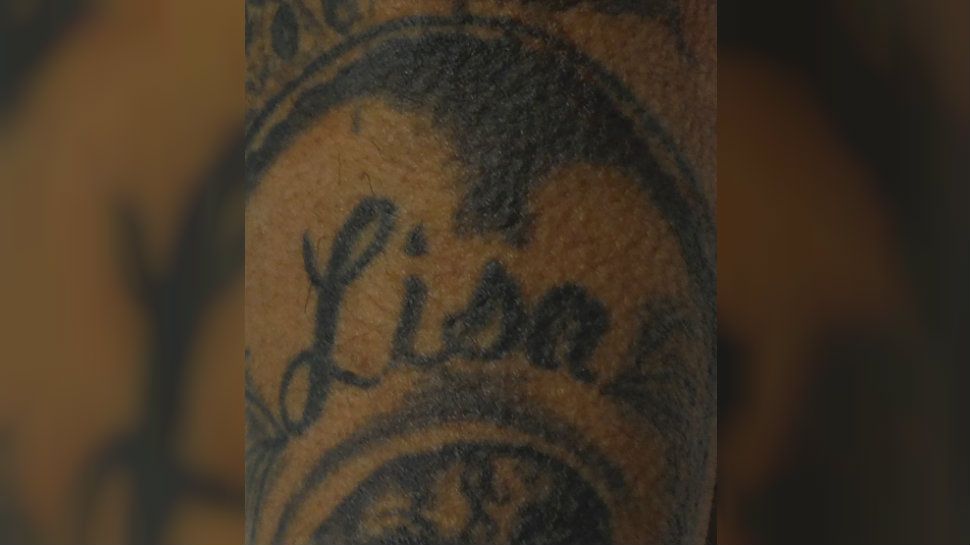 Part of the "Lisa" tattoo on the man's left arm. 
