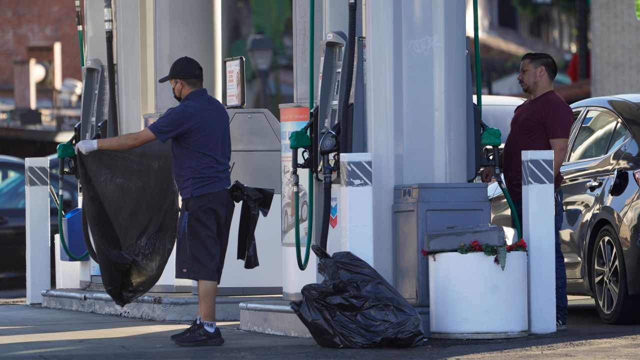 A customer looks at gasoline prices before pumping at a Chevron gas station downtown Los Angeles Friday, Feb. 18, 2022. (AP Photo/Damian Dovarganes)