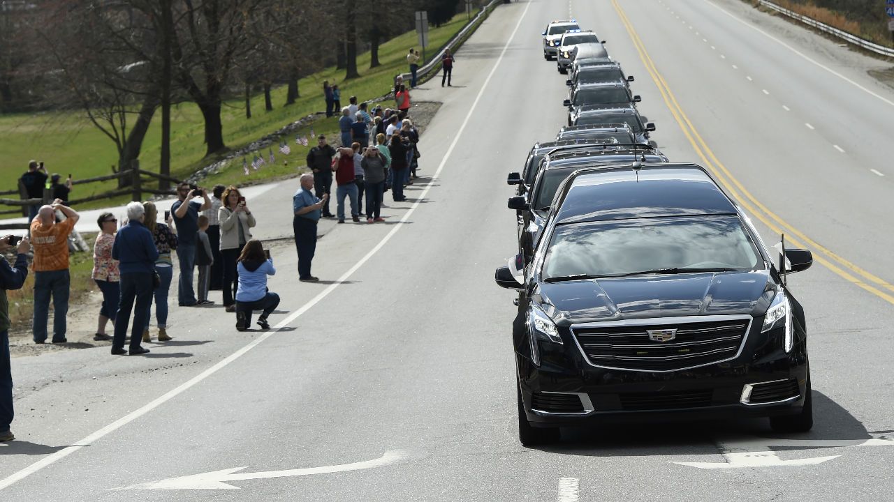 Rev. Billy Graham's motorcade passes by a group of people lining the streets.
