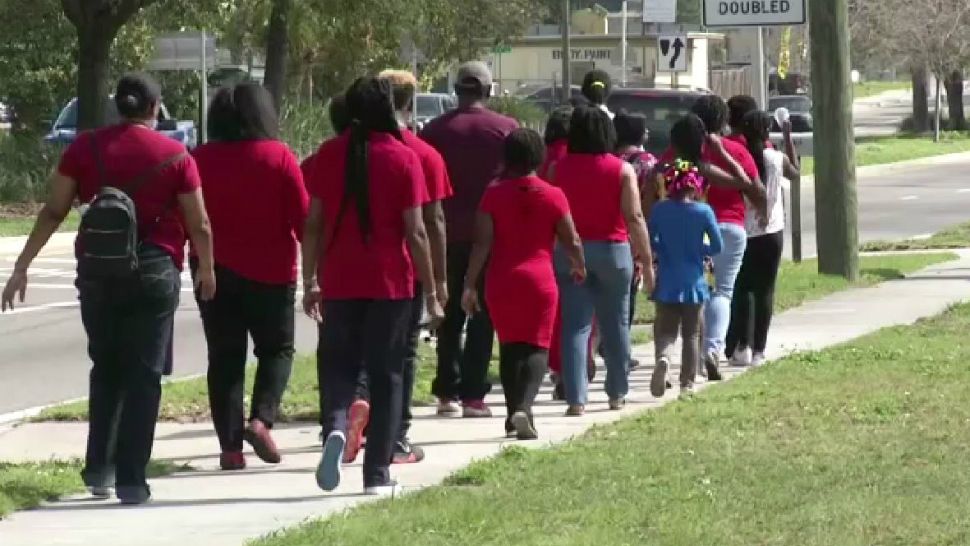 Members of the Holsey Temple CME Church in Ybor Heights march through the neighborhood wearing red Sunday in memory of Takiya Fullwood. (Spectrum Bay News 9)