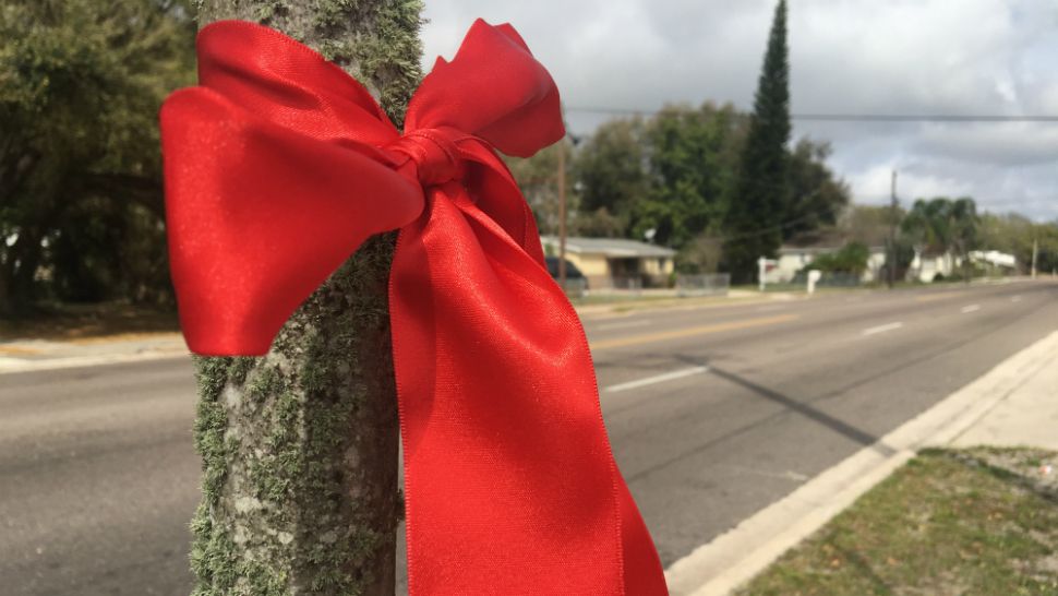 Church members tied red ribbons around posts on 15th Street North on Sunday in memory of 18-year-old Takiya Fullwood, who was shot and killed a week ago. (Spectrum Bay News 9)