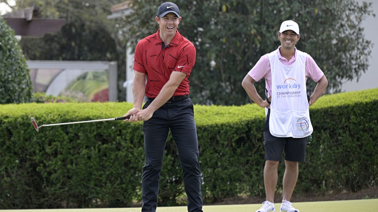 Rory McIlroy, left, of Northern Ireland, wears clothing in honor of fellow golfer Tiger Woods, while warming up on the practice green, during the final round of the Workday Championship golf tournament Sunday, Feb. 28, 2021, in Bradenton, Fla. (AP Photo/Phelan M. Ebenhack)