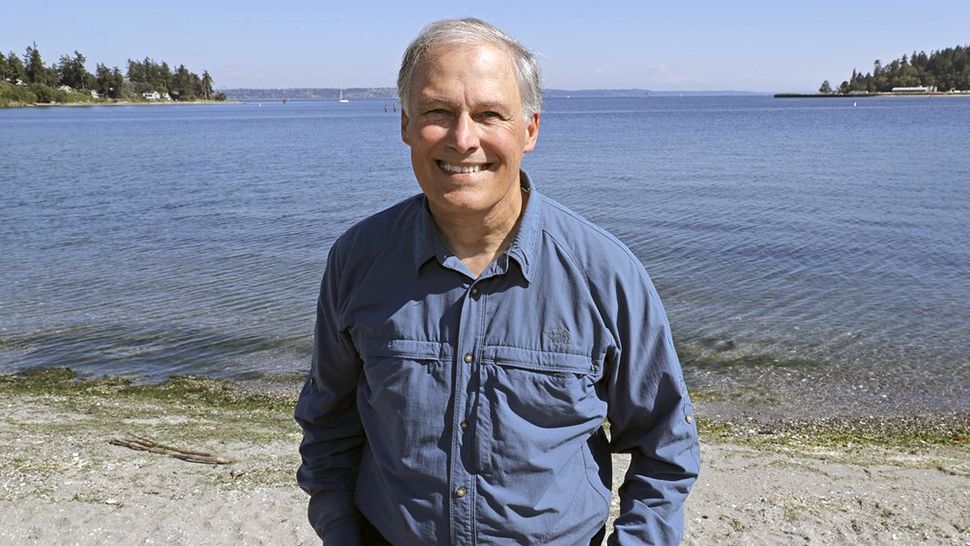 In this photo taken July 23, 2018, Washington Gov. Jay Inslee poses for a photo on the beach near his home on Bainbridge Island, Wash. Inslee is adding his name to the growing 2020 Democratic presidential field. The 68-year-old is announcing his bid Friday, March 1, 2019, in Seattle after recent travels to two of the four early-nominating states. (AP Photo/Ted S. Warren)