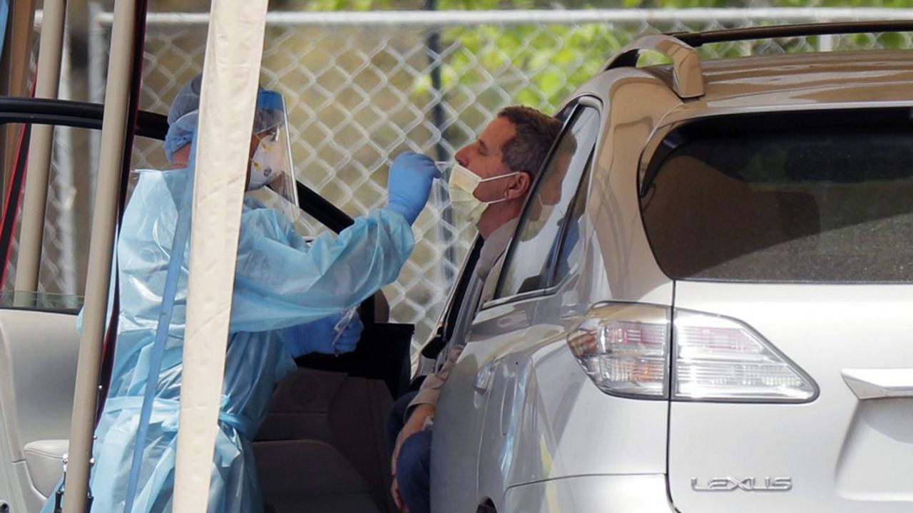 A medical worker tests a person for the coronavirus at a drive-thru facility primarily for first responders and medical personnel in San Antonio, Texas, on Tuesday. (Eric Gay/AP)