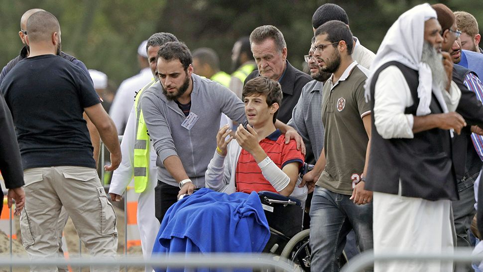 Zaed Mustafa, in wheelchair, brother of Hamza and son of Khalid Mustafa killed in the Friday March 15 mosque shootings reacts during the burial at the Memorial Park Cemetery in Christchurch, New Zealand, Wednesday, March 20, 2019. (AP Photo/Mark Baker)