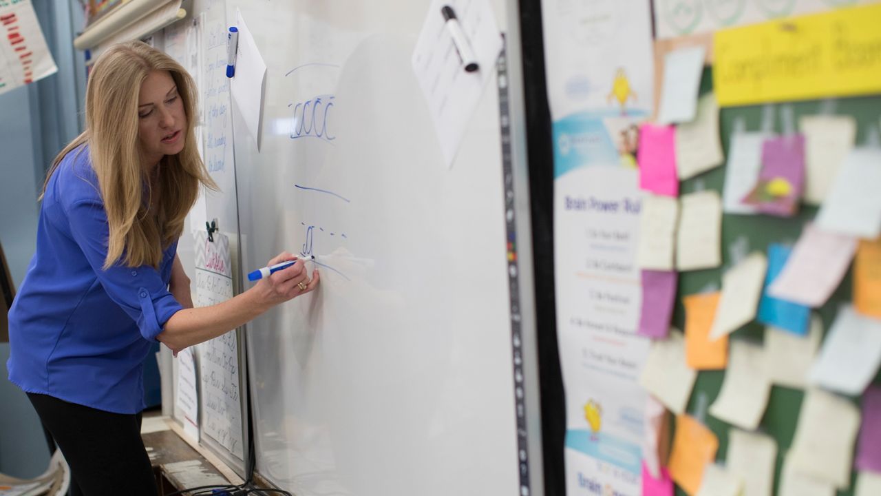 A teacher writes on a whiteboard in this file image. (Associated Press)