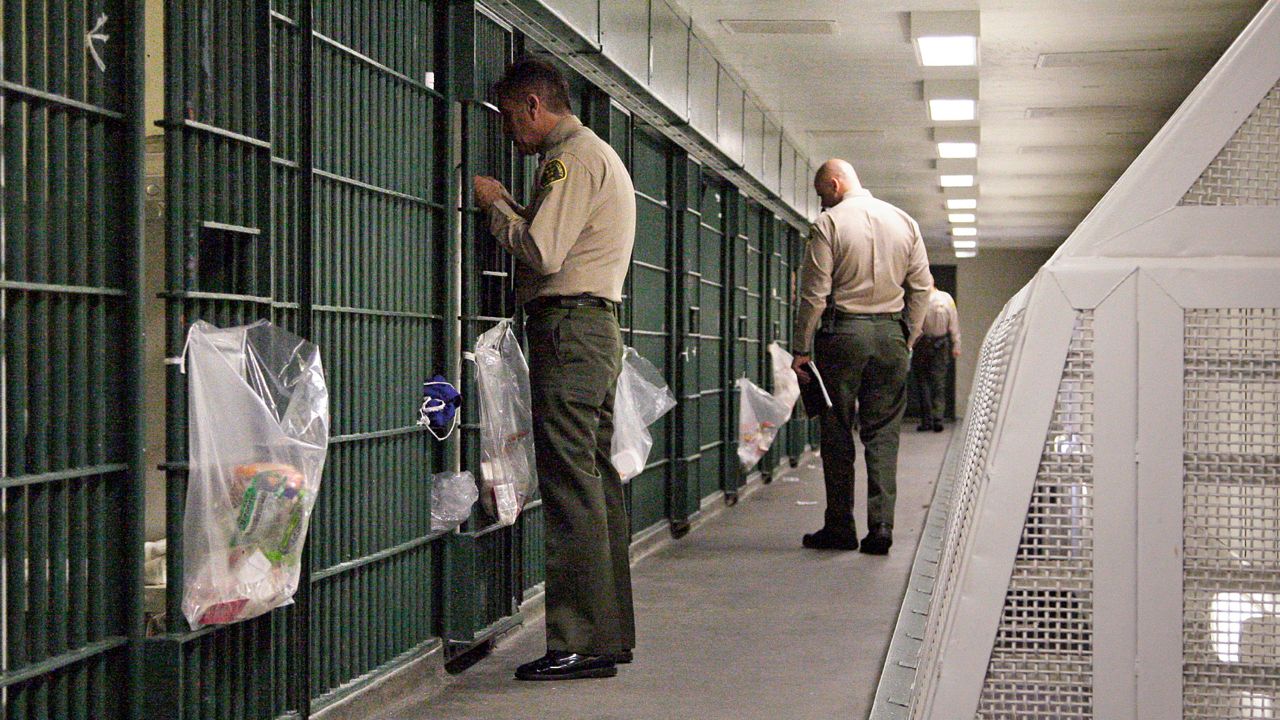 In this Oct. 3, 2012, file photo, Los Angeles County Sheriff's deputies inspect a cell block at the Men's Central Jail in downtown Los Angeles. (AP Photo/Reed Saxon, File)