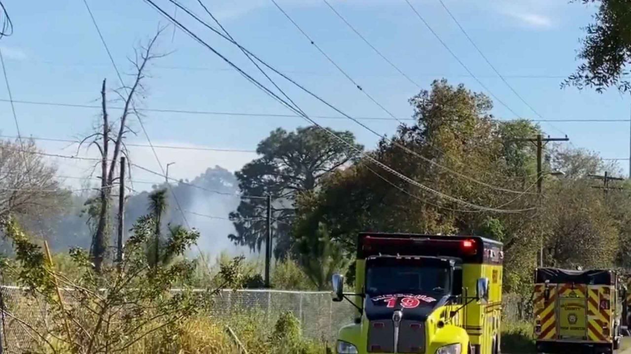 Hillsborough County Fire Rescue crews work to put out a brush fire near Linebaugh Avenue and Eagle Trail Drive in Tampa. (Trevor Pettiford/Spectrum Bay News 9)