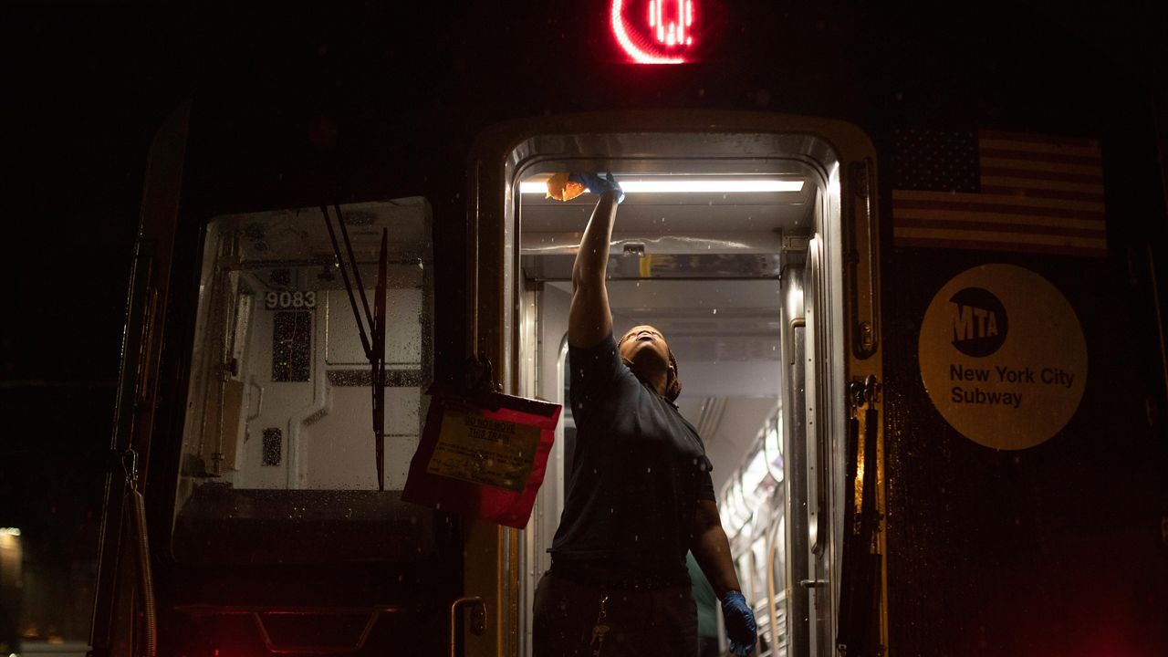 Worker cleaning subway car