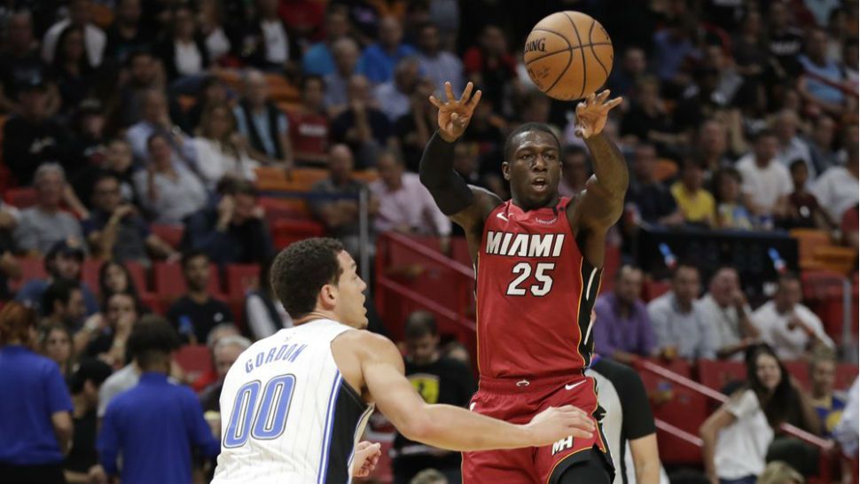 Miami Heat guard Kendrick Nunn (25) passes the ball past Orlando Magic forward Aaron Gordon (00) during the first half of an NBA basketball game Wednesday, March 4, 2020, in Miami. (AP Photo/Wilfredo Lee)