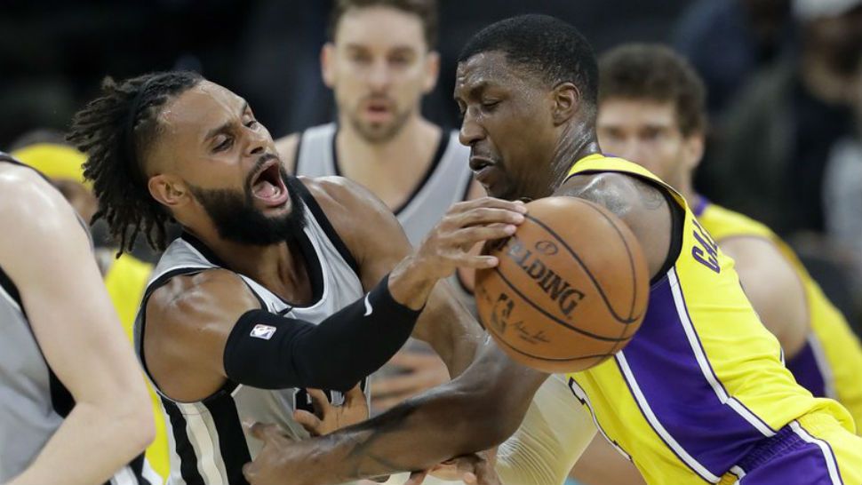 San Antonio Spurs guard Patty Mills, left, is pressured by Los Angeles Lakers guard Kentavious Caldwell-Pope (1) during the first half of an NBA basketball game, Saturday, March 3, 2018, in San Antonio. (AP Photo/Eric Gay)