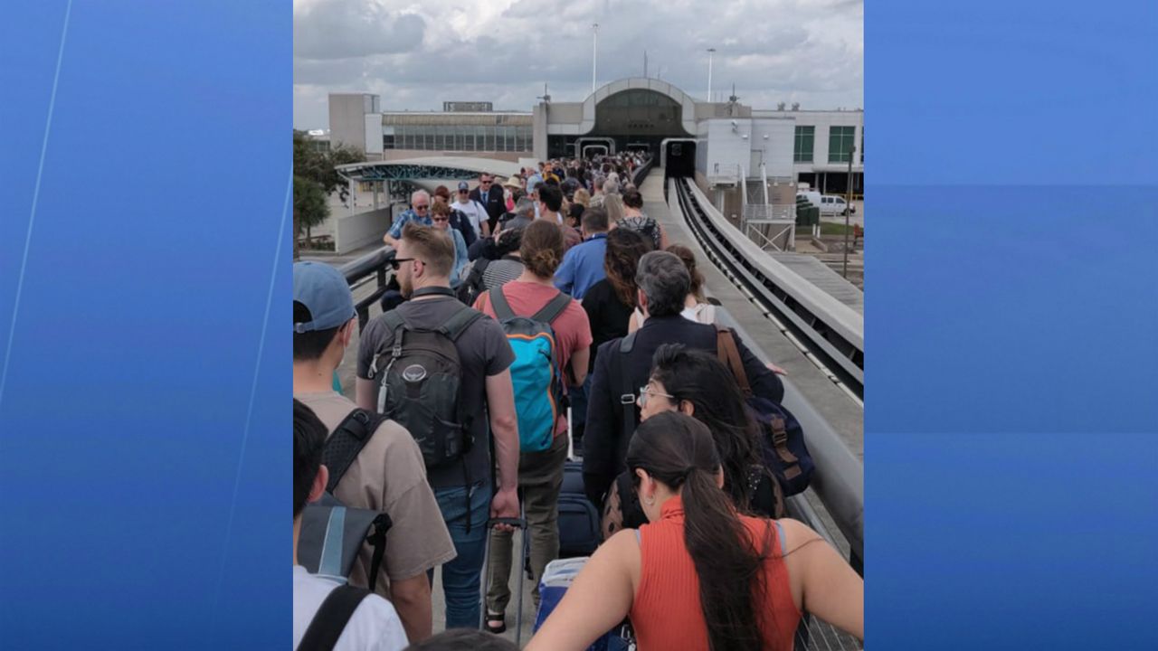 Passengers walk back to the terminal at Orlando International Airport after the Automated People Mover to Gates 1-29 went down Thursday afternoon. (Courtesy of Rafael Palacio)