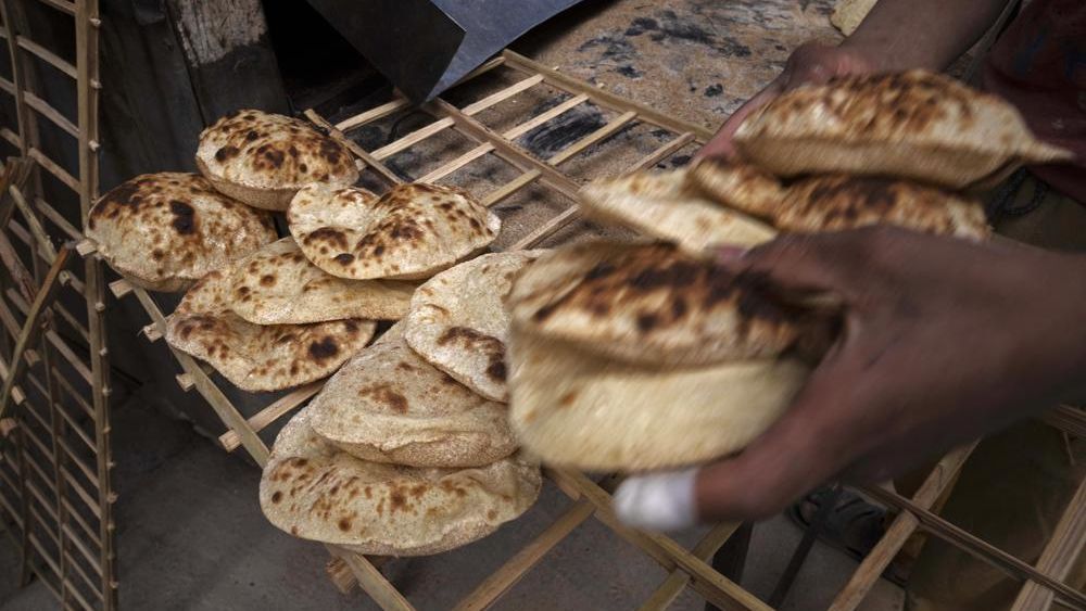 A worker collects Egyptian traditional 'baladi' flatbread, at a bakery, in el-Sharabia, Shubra district, Cairo, Egypt, Wednesday, March 2, 2022. The Russian tanks and missiles besieging Ukraine also are threatening the food supply and livelihoods of people in Europe, Africa and Asia who rely on the vast, fertile farmlands of the Black Sea region. (AP Photo/Nariman El-Mofty)