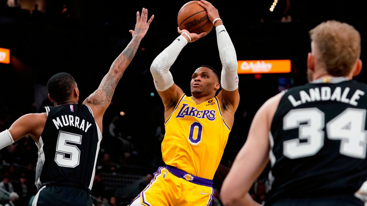 Los Angeles Lakers guard Russell Westbrook (0) shoots over San Antonio Spurs guard Dejounte Murray (5) during the first half of an NBA basketball game, Monday, March 7, 2022, in San Antonio. (AP Photo/Eric Gay)