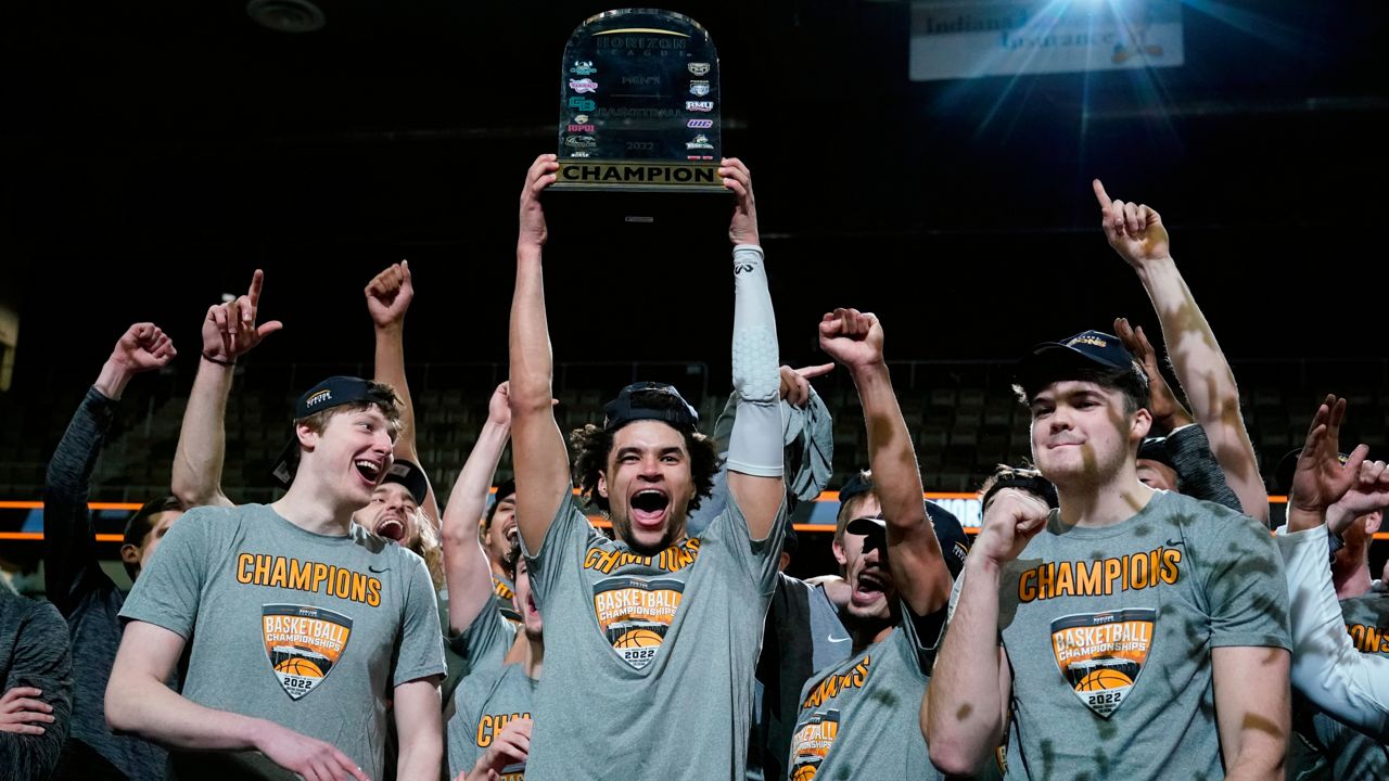 Wright State's Tanner Holden holds up the trophy and celebrates with teammates following an NCAA college basketball game against Northern Kentucky for the Horizon League men's tournament championship Tuesday, March 8, 2022, in Indianapolis. Wright State won 72-71. (AP Photo/Darron Cummings)