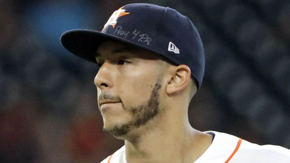 FILE - This is a Sept. 23, 2017, file photo showing Houston Astros shortstop Carlos Correa wears a message on his cap for those affected by the Hurricane in Puerto Rico during the second inning of a baseball game. Correa skipped the Astros’ visit to the White House, Monday, March 12, 2018, to help arrange for more relief supplies for shipment to hurricane-ravaged Puerto Rico, where he grew up. (AP Photo/David J. Phillip, File)
