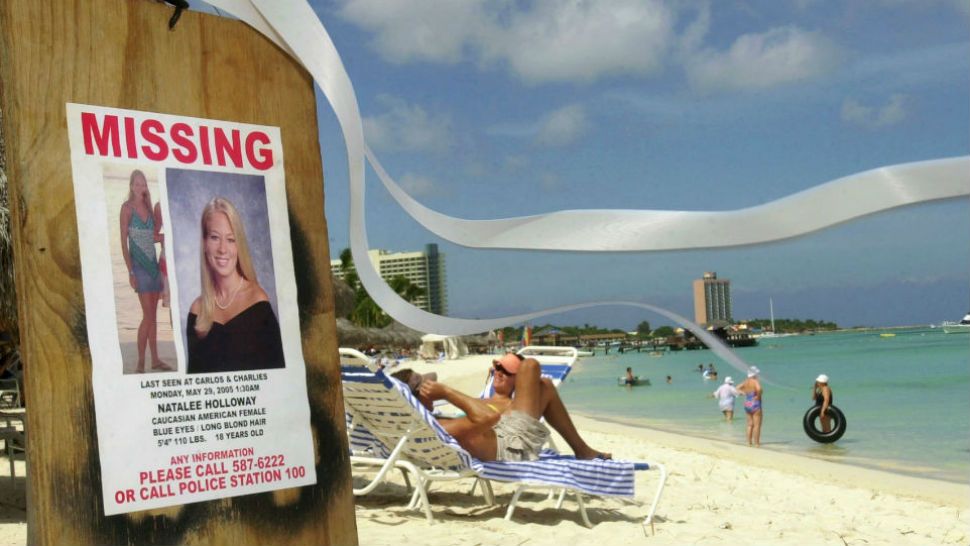 FILE - This June 10, 2005 file photo shows a missing poster for Natalee Holloway, a high school graduate of Mountain Brook, Alabama who disappeared while on a graduation trip to Aruba on May 30, 2005, on Palm Beach where tourists sunbathe in Aruba. Aruba prosecutors said Wednesday, May 20, 2015 a tip about the potential location of Holloway's body turned out to be false after spending weeks investigating the claim in the unsolved, decade-long disappearance of the U.S. teen. (AP Photo/Leslie Mazoch, File)