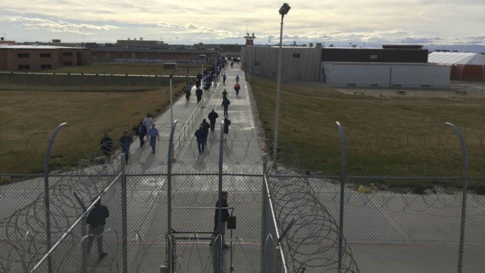 In this Jan. 30, 2018, photo inmates walk across the grounds of the Idaho State Correctional Institution in Kuna, Idaho. The medium-security prison south of Boise was where Glenn Cox, serving time on a drunken driving charge, was assaulted and killed in his cell last fall. (AP Photo/Rebecca Boone)