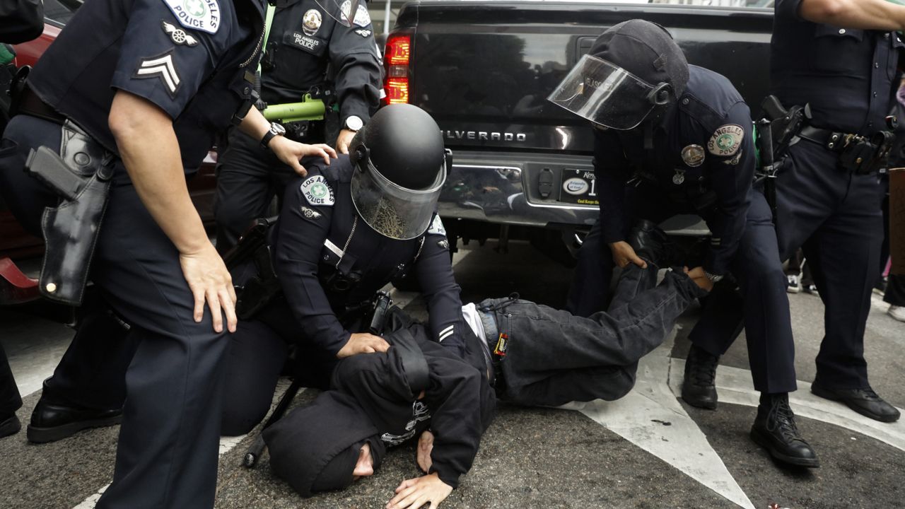 Police officers arrest a man during a protest over the death of George Floyd, Friday, May 29, 2020, in Los Angeles. (AP Photo/Jae C. Hong)