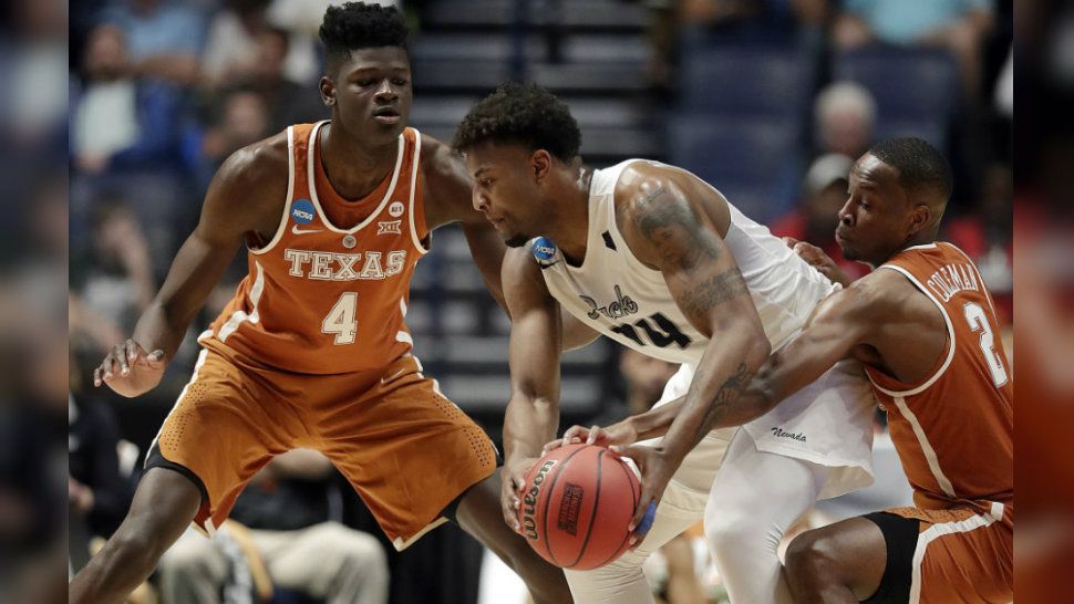 Texas forward Mohamed Bamba (4) and guard Matt Coleman (2) pressure Nevada guard Jordan Caroline (24) in the first half of a first-round game of the NCAA college basketball tournament in Nashville, Tenn., Friday, March 16, 2018. (AP Photo/Mark Humphrey)