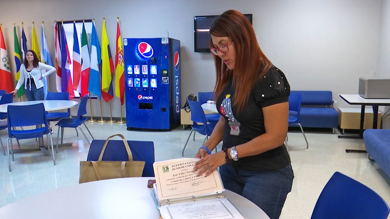 A woman in a black shirt is looking through a binder.