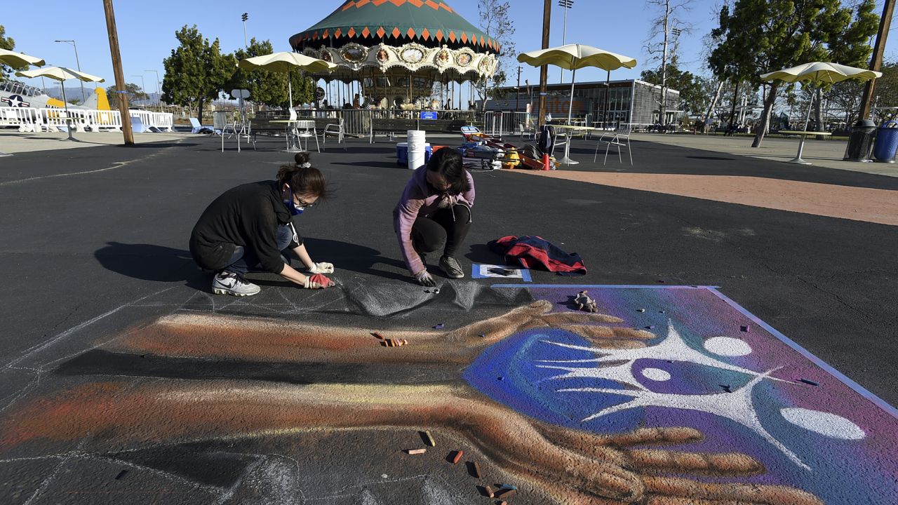 Orange County School of the Arts students lift up hope, creating art near the balloon at Irvine's Great Park on Sunday, Feb. 28, 2021 in Irvine, Calif. (Jordan Strauss/AP Images for City of Hope Newport Beach)