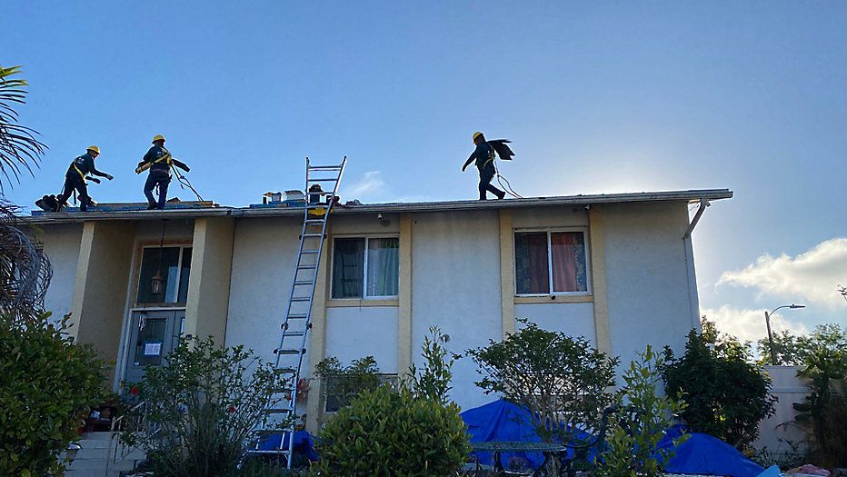 Workers with St. John's Roofing Company complete repairs on a Pine Hills home on Thursday, March 17.