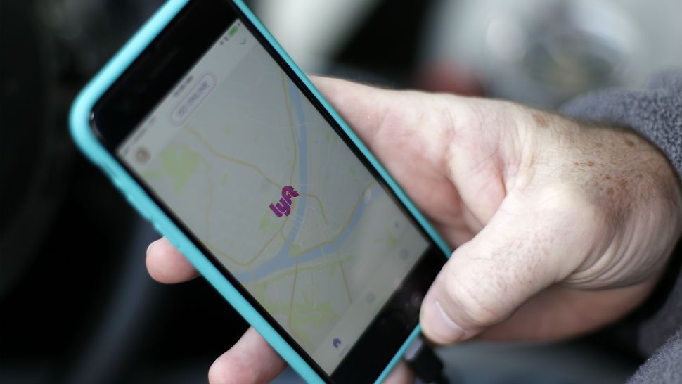 In this Jan. 31, 2018, photo, a Lyft driver opens the Lyft app on his phone while waiting for a fare in Pittsburgh. (AP Photo/Gene J. Puskar)