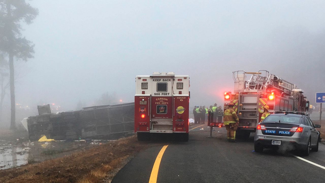 Emergency responders at the scene after a charter bus overturned on an Interstate 95 exit near Kingwood, Va., Tuesday, March 19, 2019. (Virginia State Police via AP)
