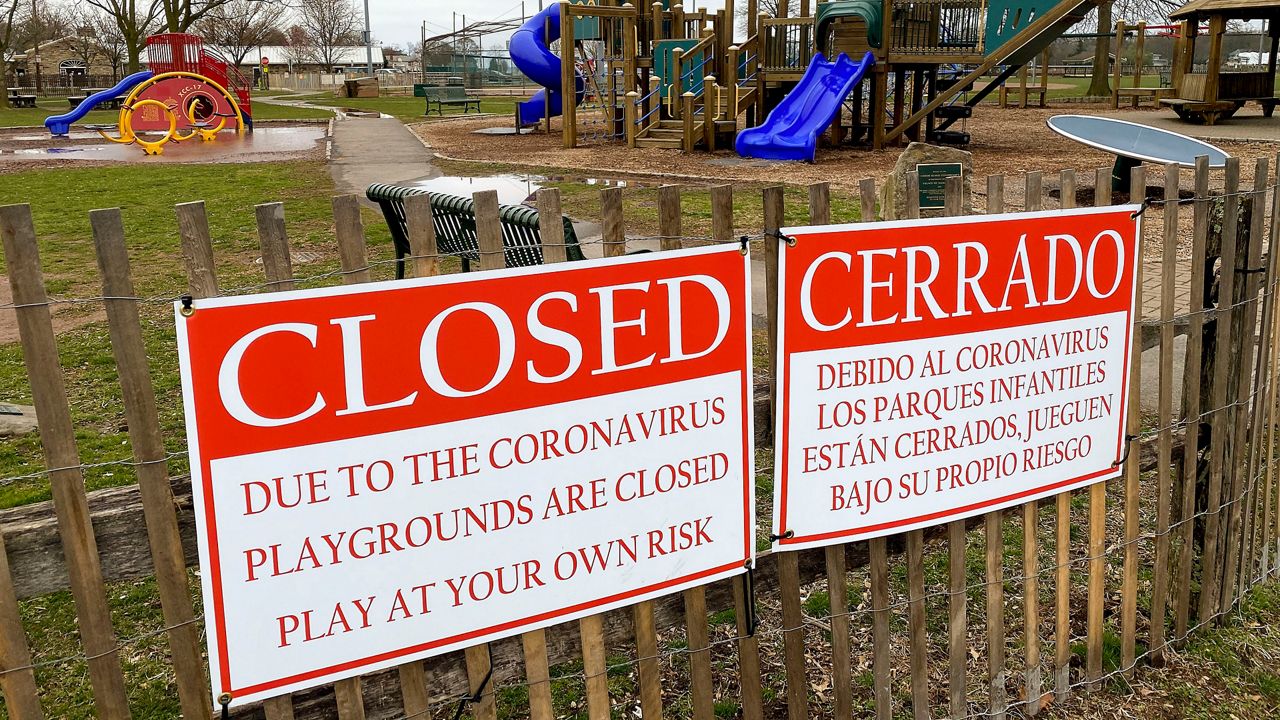 Red signs noting the closure of the Harbor Island Park playground in Mamaroneck, New York.