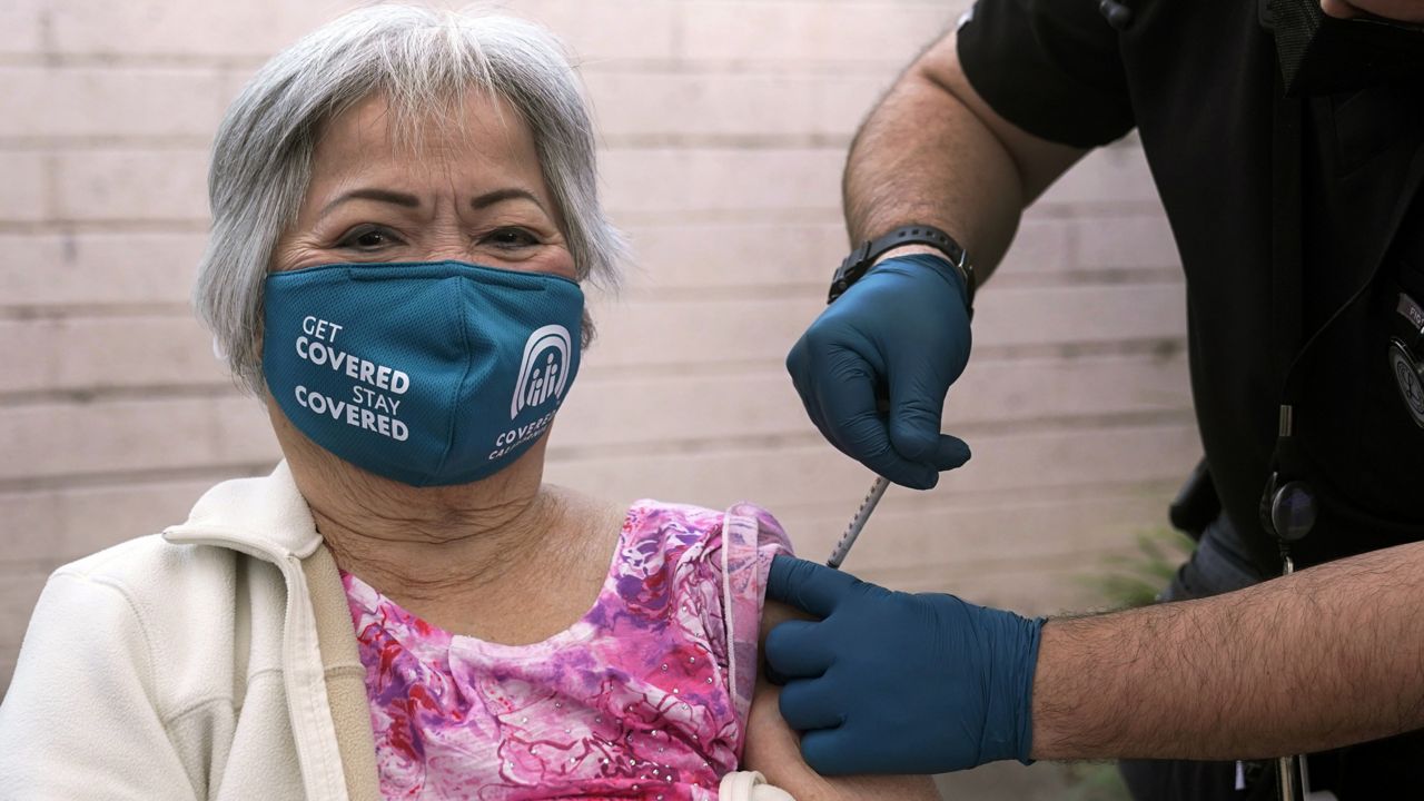 Hoa Pham gets her second dose of Pfizer's COVID-19 vaccine at Families Together of Orange County Community Health Center, Friday, Feb. 26, 2021, in Tustin, Calif. (AP Photo/Marcio Jose Sanchez)