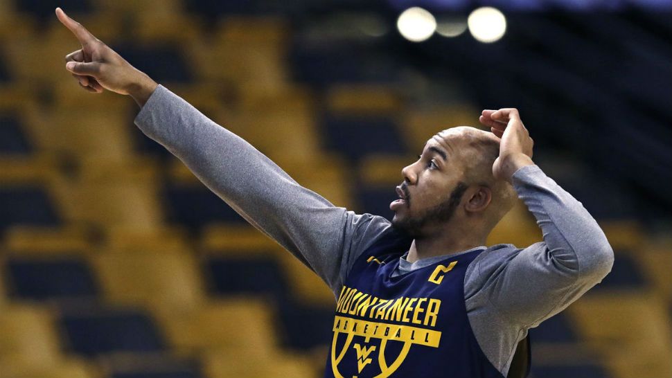 West Virginia's Jevon Carter points towards the scoreboard prior to a practice at the NCAA men's college basketball tournament in Boston, Thursday, March 22, 2018. (AP Photo/Charles Krupa)