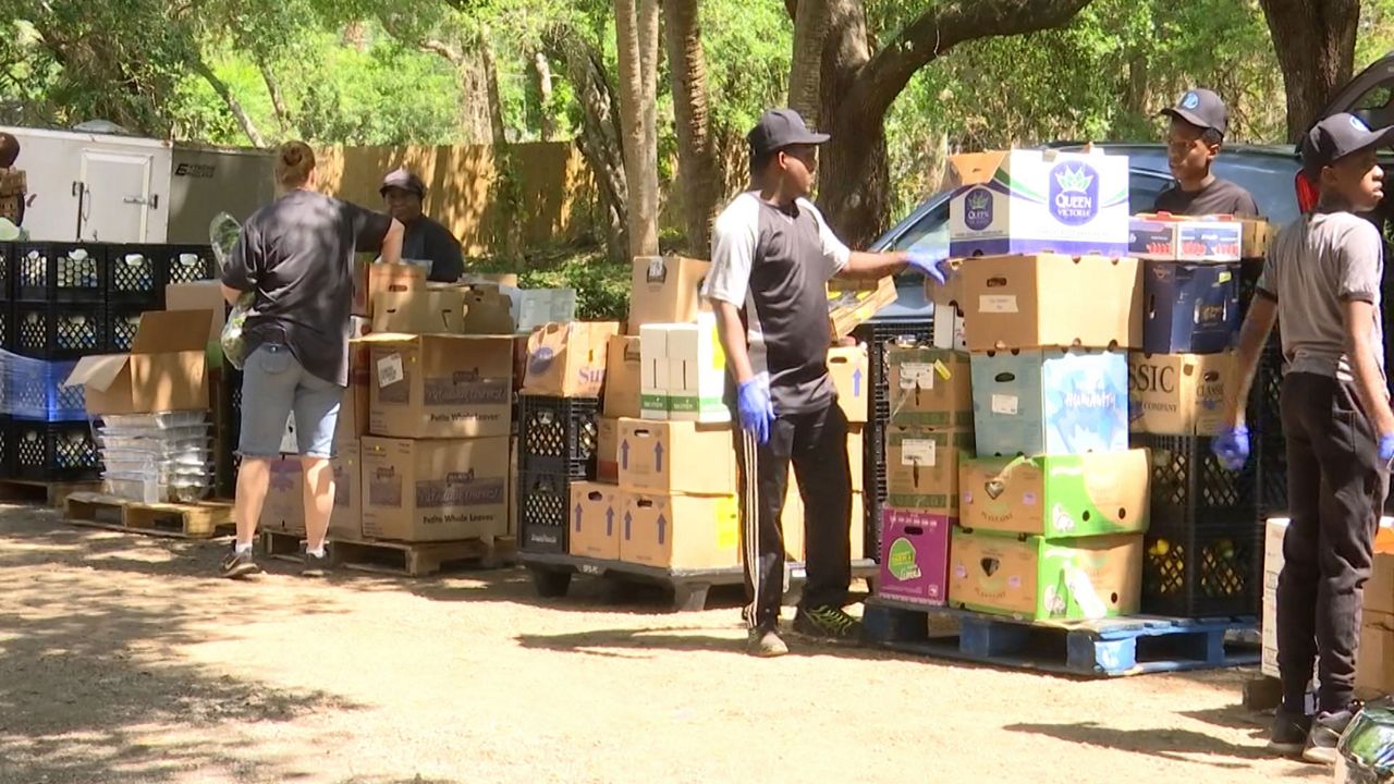 Volunteers set up a drive-through food pantry at Hands for Help International in Palm Bay. (Spectrum News)