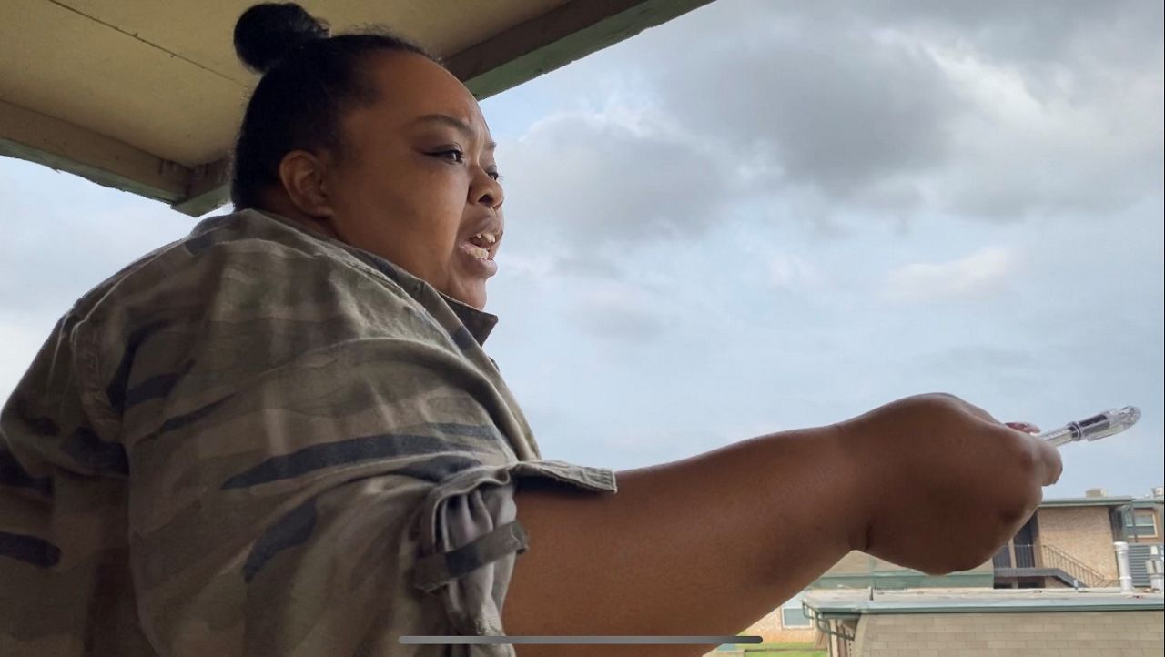 Taniquewa Brewster talks to her fellow Mount Carmel Apartment residents from her balcony. (Spectrum News 1)