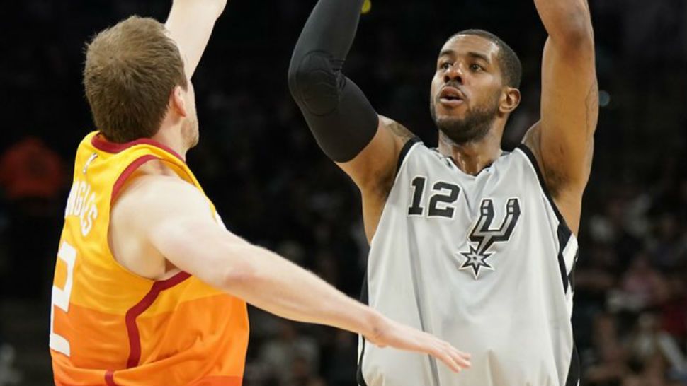 San Antonio Spurs' LaMarcus Aldridge (12) shoots against Utah Jazz's Joe Ingles during the first half of an NBA basketball game Friday, March 23, 2018, in San Antonio. (AP Photo/Darren Abate)