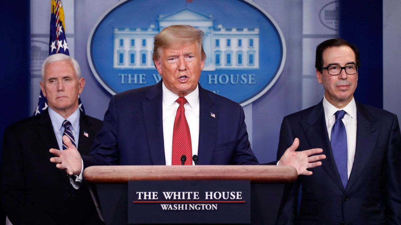 President Donald Trump speaks about the coronavirus in the James Brady Briefing Room, Wednesday, March 25, 2020, in Washington, as Vice President Mike Pence and Treasury Secretary Steven Mnuchin listen. (AP Photo/Alex Brandon)