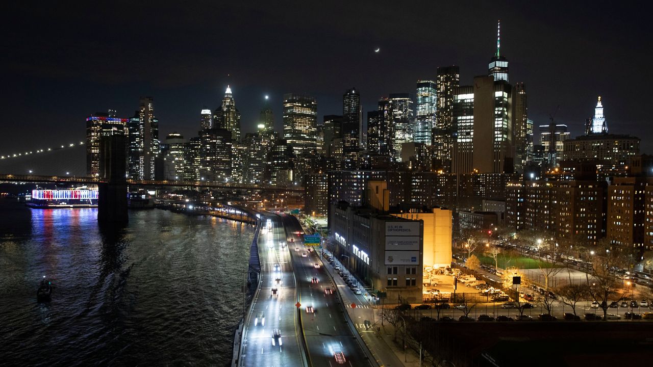 A March 26, 2020, file photo of cars driving along the FDR Drive next to the Manhattan skyline