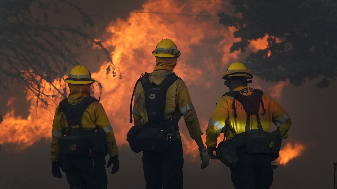 Members of a Los Angeles County Fire crew make a stand to protect a home from the advancing Bobcat Fire along Cima Mesa Rd. Friday, Sept. 18, 2020, in Juniper Hills, Calif. (AP Photo/Marcio Jose Sanchez)