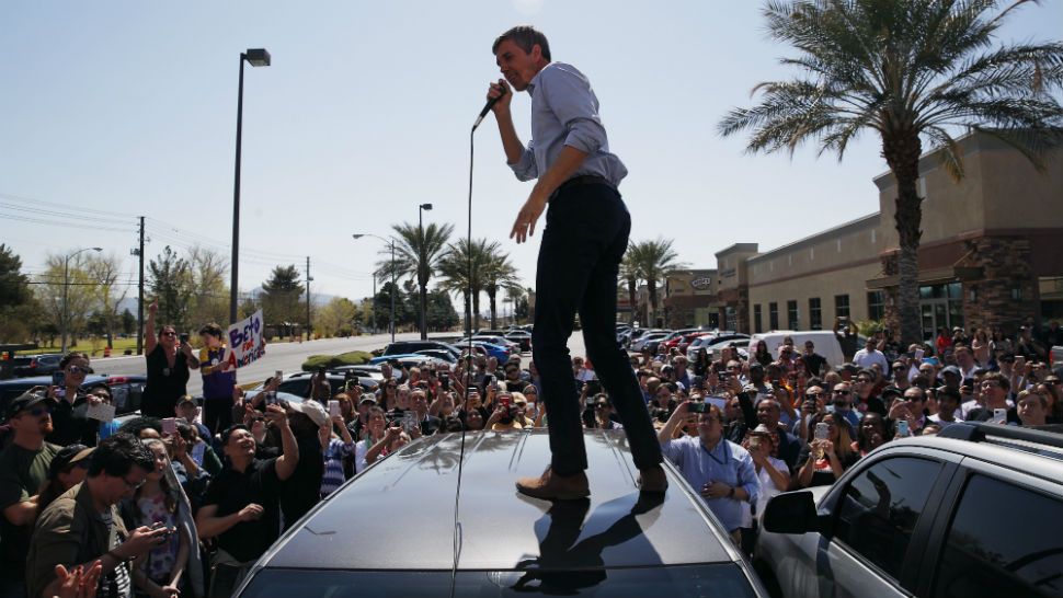 Democratic presidential candidate and former Texas congressman Beto O'Rourke speaks from the roof of his car to an overflow crowd at a campaign stop at a coffee shop Sunday, March 24, 2019, in Las Vegas. (AP Photo/John Locher)
