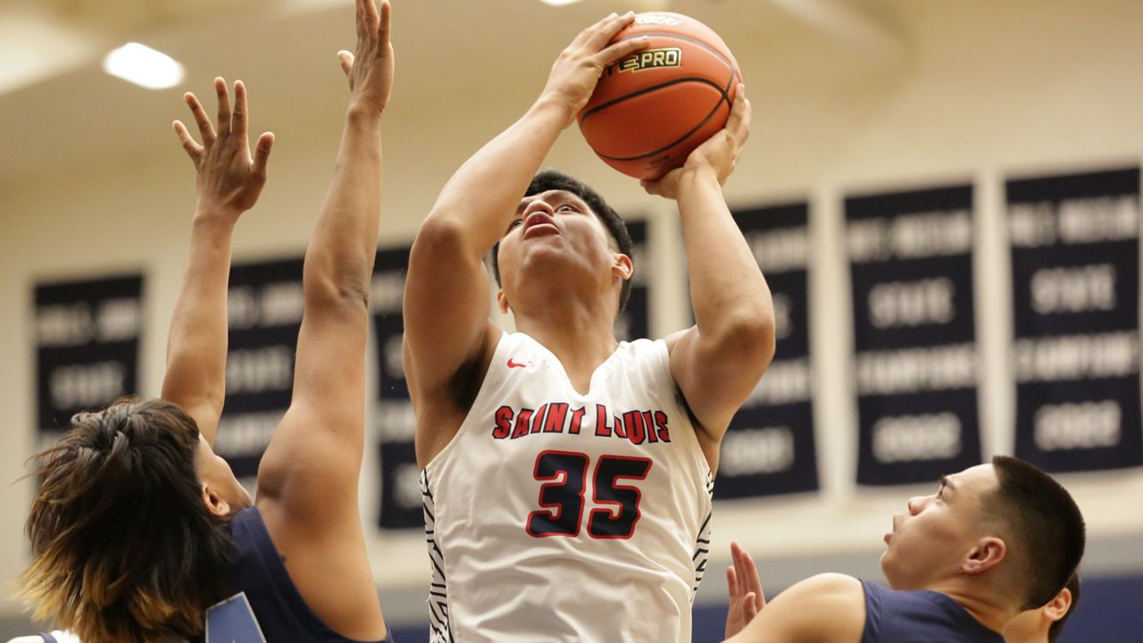 Saint Louis forward Pupualii Sepulona looked to score inside against Kailua's Na‘i Iwaki and Elijah Stietzel.