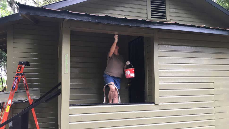 A volunteer painting a Lakeland home as part of an organized neighborhood clean-up effort, Saturday, March 16, 2019. (Stephanie Claytor/Spectrum Bay News 9)