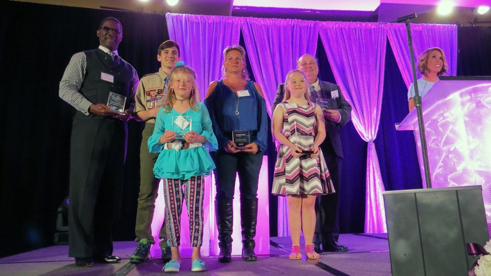 The Everyday Hero award winners stand on stage as co-hostess Ybeth Bruzual looks on. (Anthony Leone, staff)