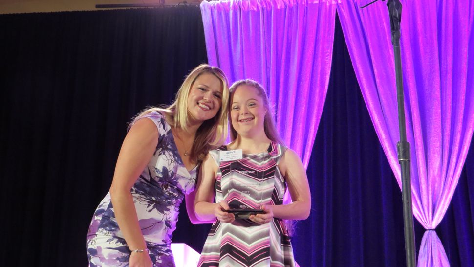 Spectrum News 13 hostess Erin Murray stands with Everyday Hero of the Year Faith-Christina Duncan, who was honored for creating quilts for babies with Down syndrome, a condition she has herself. (Anthony Leone, staff)            