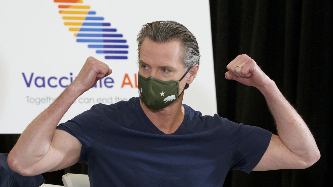 California Gov. Gavin Newsom reacts after being inoculated by Dr. Mark Ghaly, Secretary of California Health and Human Services, with the new one-dose Janssen COVID-19 vaccine by Johnson & Johnson at the Baldwin Hills Crenshaw Plaza in Los Angeles Thursday, April 1, 2021. (AP Photo/Damian Dovarganes)